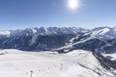 Luftaufnahme einer Skipiste im Winter mit Seilbahn bei wolkenlosem Himmel